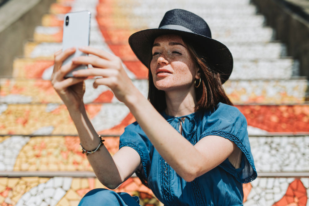 Woman In Black Hat Taking A Selfie
